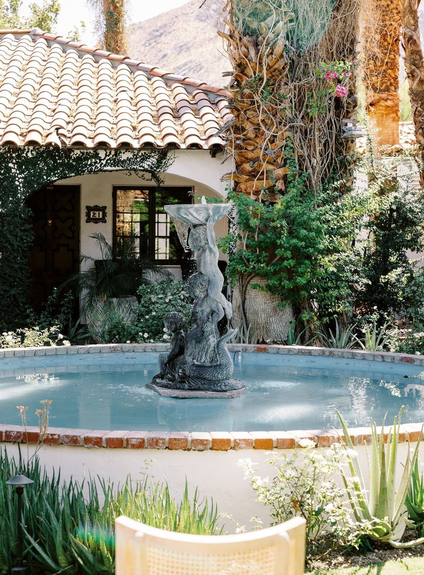 Fountain seen in the courtyard ceremony space at Ingleside Estate, with florals for wedding welcome brunch backdrop
